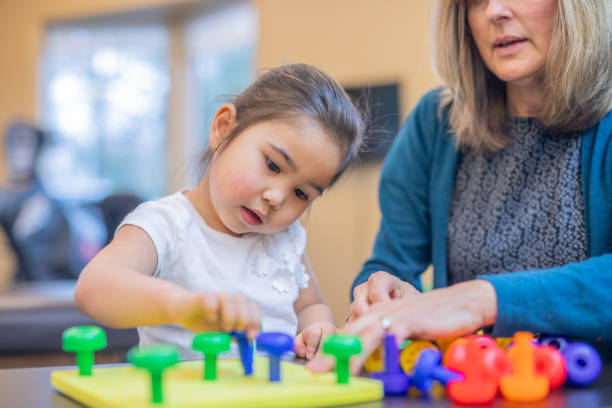 istock Occupational therapist works with a young ethnic girl 1078576002