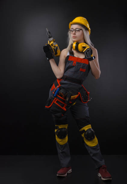 istock girl in construction clothes and protective equipment posing with a screwdriver 1078581140