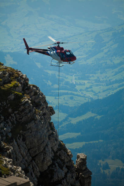 istock helicopter transporting construction goods to construction site in the swiss alpes 1078583710
