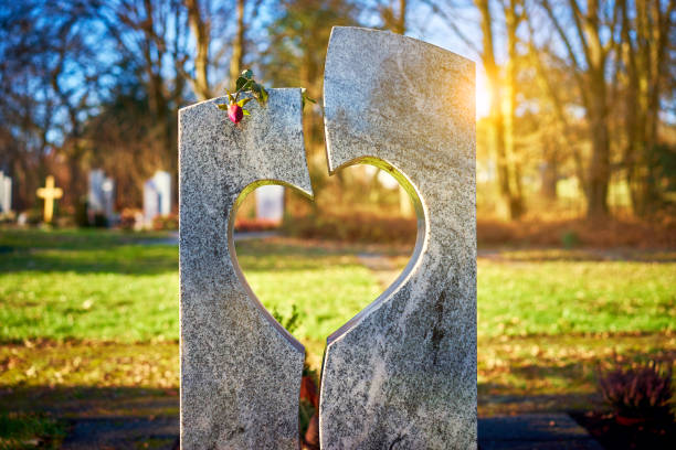 pierre tombale avec coeur rose flétrie - cimetière photos et images de collection