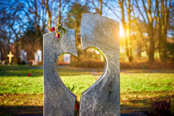 pierre tombale avec coeur rose flétrie - new life death cemetery flower photos et images de collection