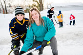 A Mother and son playing hockey having fun