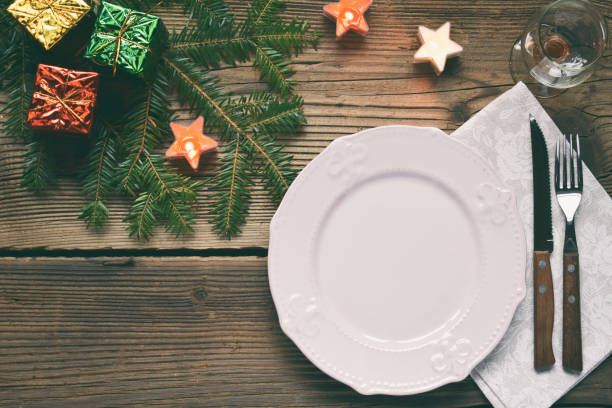 istock Empty pink plate, glass, cutlery, decorations on wooden background. Christmas table setting captured from above. Top view, flat lay. Copy space. 1078605048