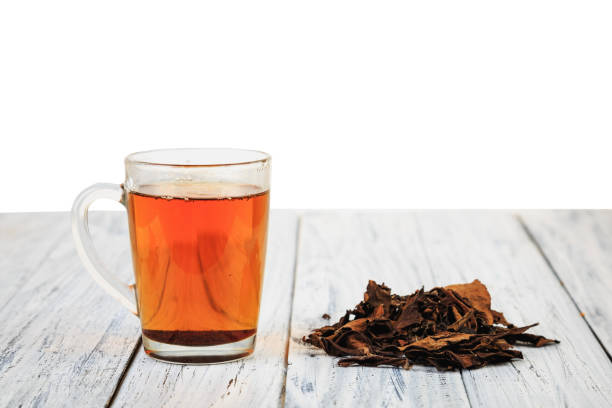 Cup of black tea and tea leaves stock photo