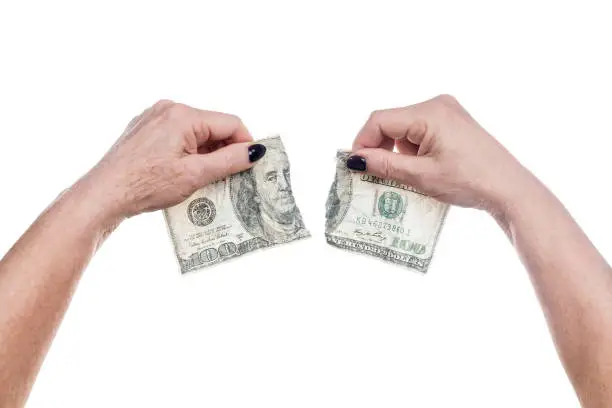 Photo of female hands tearing up dollars
