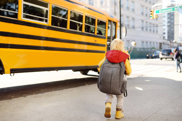 pupila con mochila con autobús amarillo sobre fondo - little boys preschooler back to school backpack fotografías e imágenes de stock