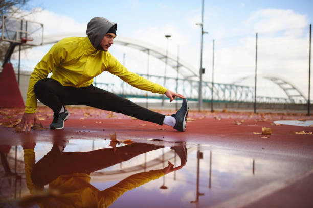 istock Young athlete man stretching his muscles before running outdoors 1078638292
