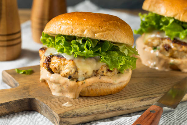 Spicy Homemade Chipotle Chicken Burger Spicy Homemade Chipotle Chicken Burger with Lettuce metal grate photos stock pictures, royalty-free photos & images
