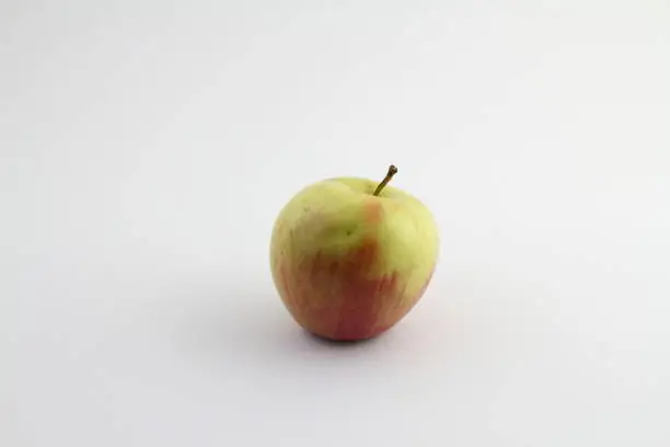 Close-up of a Green Apple on a white Background. View to a fresh Apple on a clean Background. Vegetarian Raw Food. Food and Fruit Backgrounds