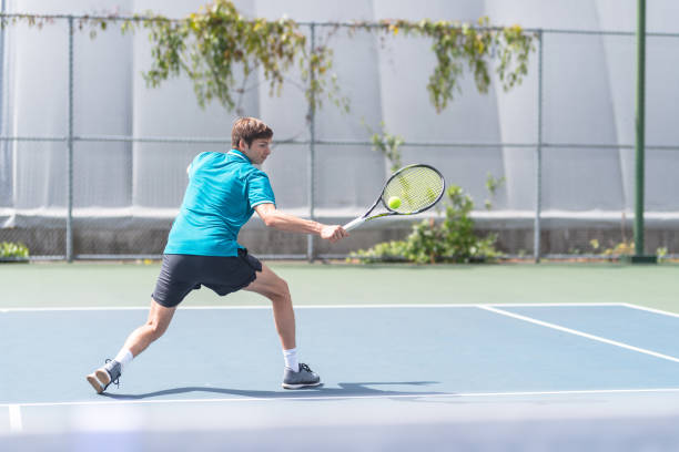 istock A young male tennis player returning a serve 1078710104