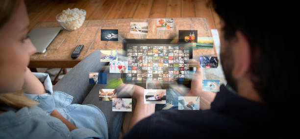 Couple using tablet for watching VOD service Couple using tablet for watching VOD service. Video On Demand television with abstract flying images Stream stock pictures, royalty-free photos & images