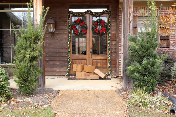 shipping packages at front door during holiday shopping season Boxes and packages next to front door during holiday christmas season. porch stock pictures, royalty-free photos & images