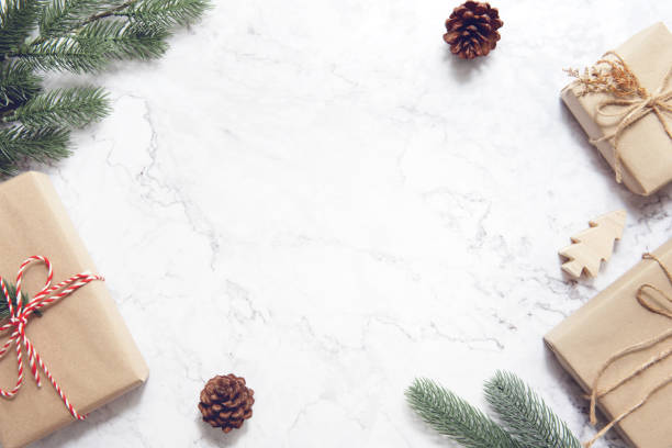 Christmas background with decorations and gift boxes on white marble.