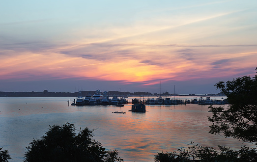 Landscape with lake, boats and sunset sky at Lake Montauk, New York, USA