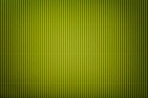 Texture of corrugated dark green paper with vignette, macro. Striped pattern of olive cardboard background, closeup.