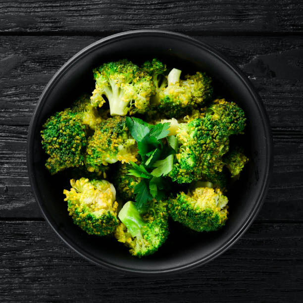 istock Boiled broccoli in a black plate. On a black background. Top view. Free space for your text. 1078904254