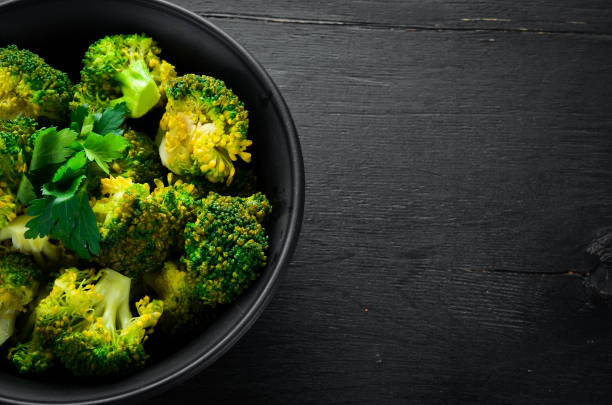 istock Boiled broccoli in a black plate. On a black background. Top view. Free space for your text. 1078910946