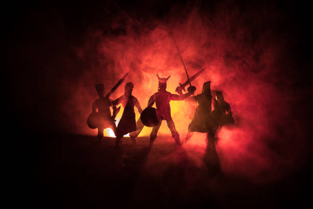 istock Medieval battle scene. Silhouettes of figures as separate objects, fight between warriors on dark toned foggy background. Night scene. 1078911106