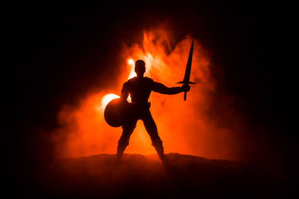 istock Medieval battle scene. Silhouettes of figures as separate objects, fight between warriors on dark toned foggy background. Night scene. 1078911116
