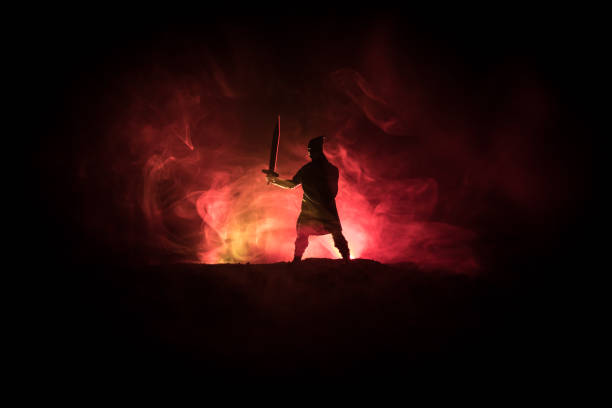 istock Medieval battle scene. Silhouettes of figures as separate objects, fight between warriors on dark toned foggy background. Night scene. 1078911138