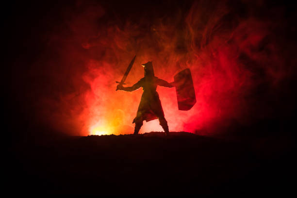 istock Medieval battle scene. Silhouettes of figures as separate objects, fight between warriors on dark toned foggy background. Night scene. 1078911146