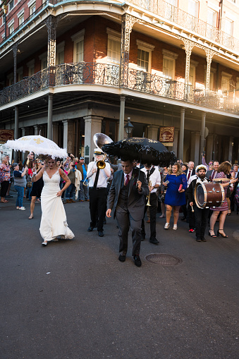 New Orleans, USA - Nov 3, 2018: A Nola second line dancing through the French quarter late in the day on Royal street.