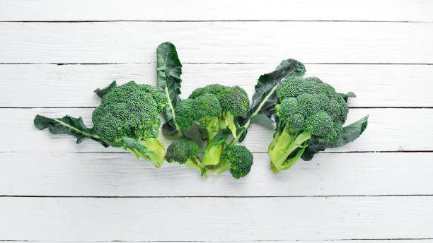 istock Broccoli. Fresh green broccoli on a white wooden table. Top view. Free copy space. 1078913700