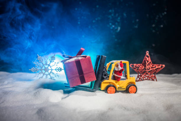 istock Miniature Gift Box by Forklift Machine on snow ,Determined Image for Christmas Holiday and Happy New Year Gift Celebration concept. 1078915950