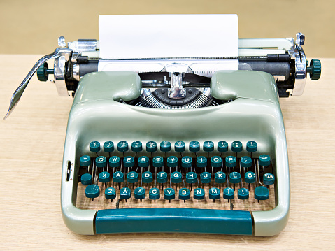 Green retro typewriter on wooden table