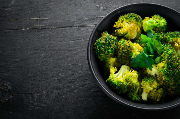 istock Boiled broccoli in a black plate. On a black background. Top view. Free space for your text. 1078920222