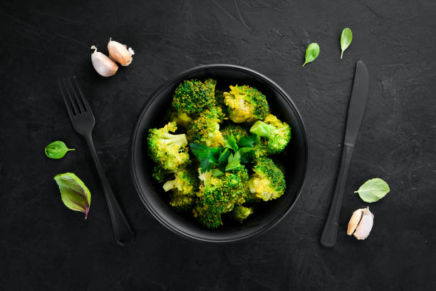 istock Boiled broccoli in a black plate. On a black background. Top view. Free space for your text. 1078920366