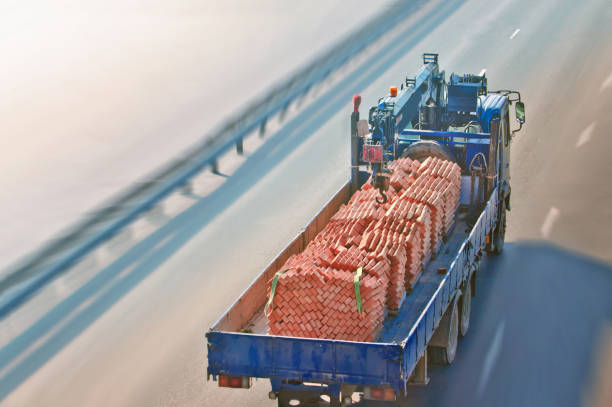 Truck with bricks rides on the road. Top view. Winter day. Tilt shift effect.