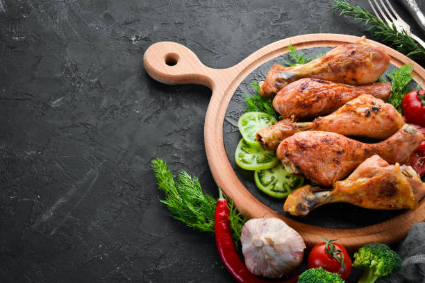 istock Baked Chicken legs on a black stone background. Meat. Top view. Free copy space. 1078922546