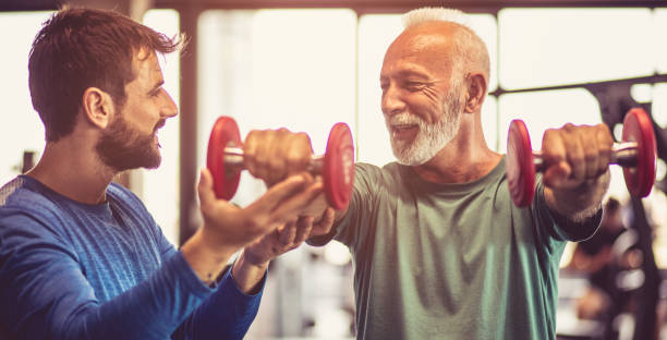 der trainer gibt ihm die unterstützung. - weight training weight bench weightlifting men stock-fotos und bilder