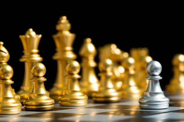 istock Silver pawn chess piece face with another gold team (Concept for company strategy, business decision and encounter the problem) 1078964088