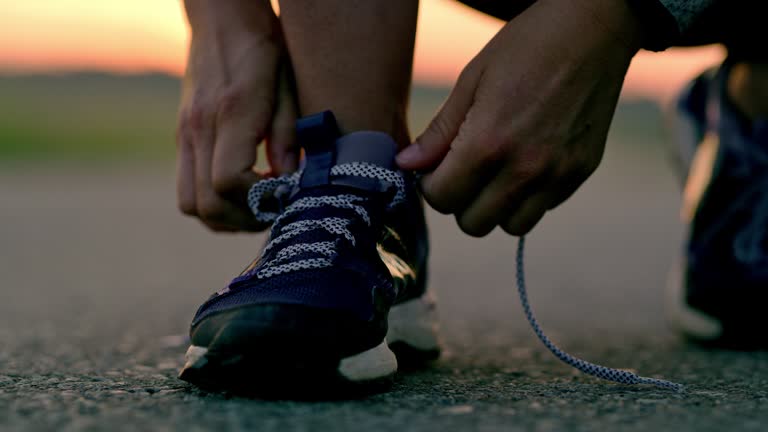 SLO MO Woman tying shoelaces on running shoes