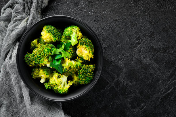 istock Boiled broccoli in a black plate. On a black background. Top view. Free space for your text. 1078966530