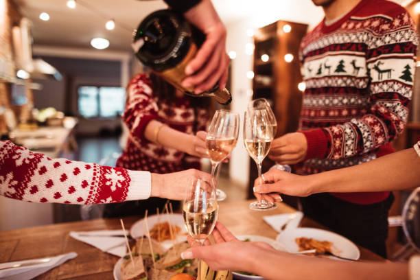 istock people toasting champagne at dinner for christmas 1078976080