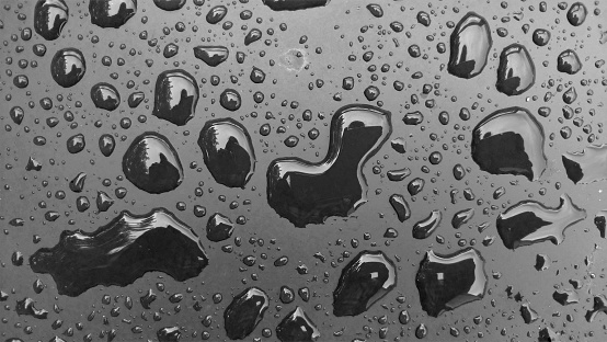 Drops of Rain or Water Drop on the Hood of the Car. Rain Drops on the Surface of the Car or on the Iron Surface Flow Down. Abstract Background and Water Texture for Design.