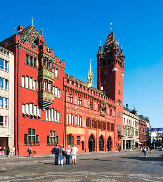 Basel, Switzerland - August 20, 2018: Marktplatz with the Rathaus in Basel, Switzerland. View at the Basel Town Hall and the Marktplatz in the center of Basel. It was erected between 1504 and 1514. It is the dominating building at the Marketplace in Basel. It is used for meetings of Cantonal Parliament and Cantonal Government Of Basel Stadt. On the Marketplace some pedestrians can be seen.