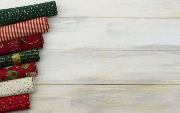 istock CHRISTMAS BACKGROUNDS. PATCHWORK CLOTH  BORDER AGAINST WHITE WOODEN DESK OR TABLE. 1078986488