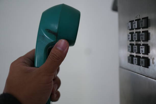 istock Man's hand with public phone. 1078995110