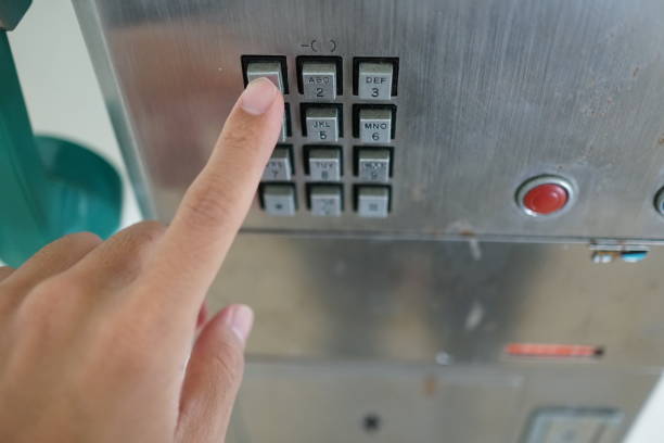 istock Man's hand with public phone. 1078997008