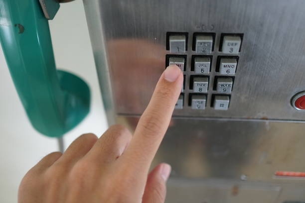 istock Man's hand with public phone. 1078997032