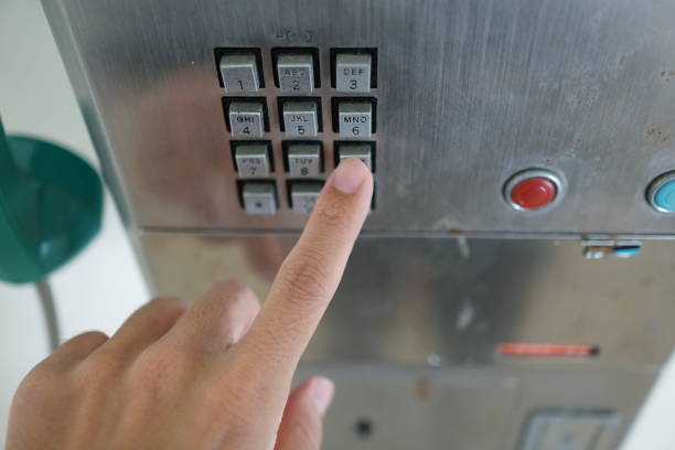 istock Man's hand with public phone. 1078997052