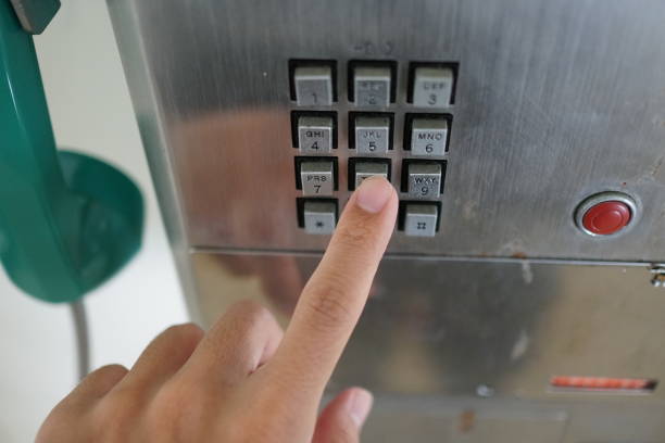 istock Man's hand with public phone. 1078997124