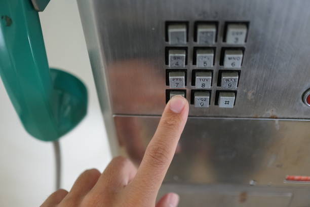 istock Man's hand with public phone. 1078997138