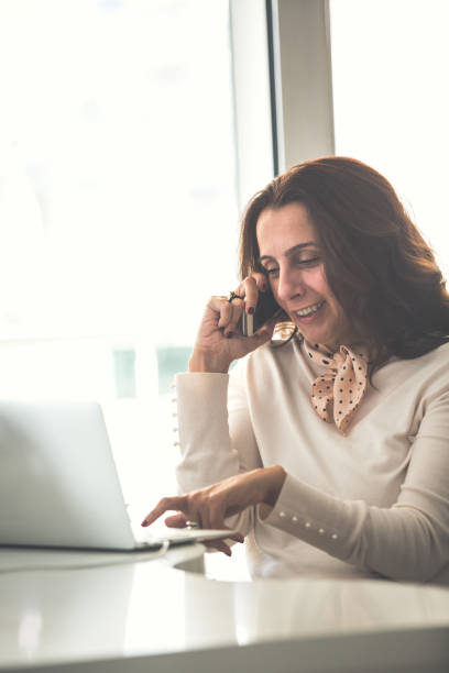 istock Businesswoman talking on cell phone while working 1079015796