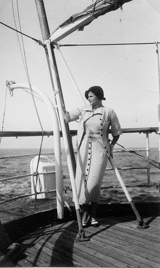 Young woman sailing with seafaring navy typical dresses. 1930s black and white film. Alassio, Liguria. Italy
