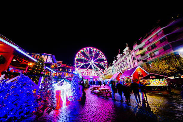 Montreux Christmas Market Montreux, Switzerland. 7th December 2018. People are walking through the central square in Montreux against the backdrop of a large Ferris wheel during the large Christmas Market at night montreux photos stock pictures, royalty-free photos & images